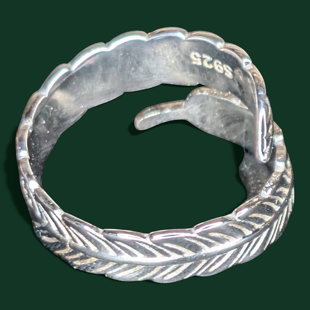 Ein raffinierter, verstellbarer Feder-Wickelring aus Sterlingsilber mit aufwendigen Details und einem geheimnisvoll schillernden Stein.