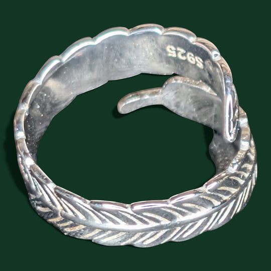 Ein raffinierter, verstellbarer Feder-Wickelring aus Sterlingsilber mit aufwendigen Details und einem geheimnisvoll schillernden Stein.