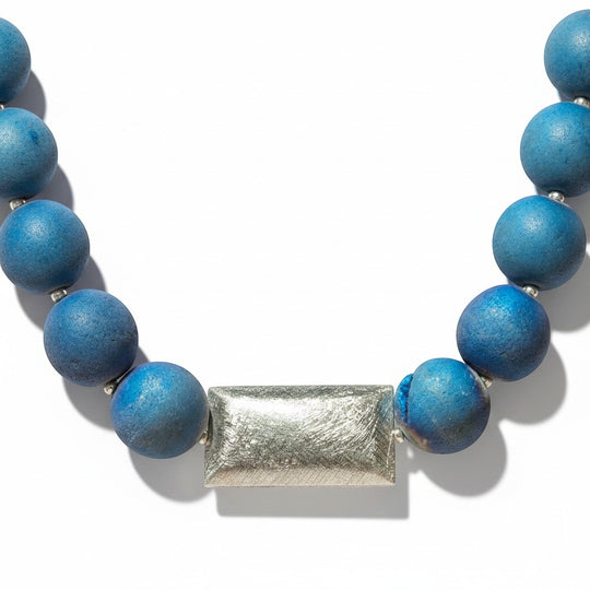 Eine elegante Halskette aus blauen Geoden-Achatperlen mit einem rechteckigen Mittelstück aus 925er Silber und dezenten Geoden Mustern.