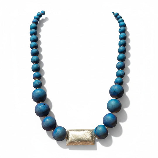 Eine elegante Halskette aus blauen Geoden-Achatperlen mit einem rechteckigen Mittelstück aus 925er Silber. Sie zeichnet sich durch unterschiedlich große Perlen und eine strukturierte Oberfläche aus.