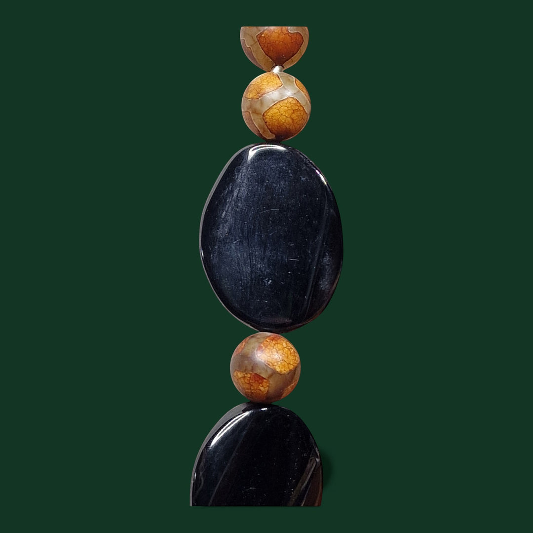 Eine auffällige Statement-Halskette von Sinnikäs mit Perlen aus schwarzem Onyx und tibetischem Achat, Akzenten aus 925er Silber, Länge 70 cm.