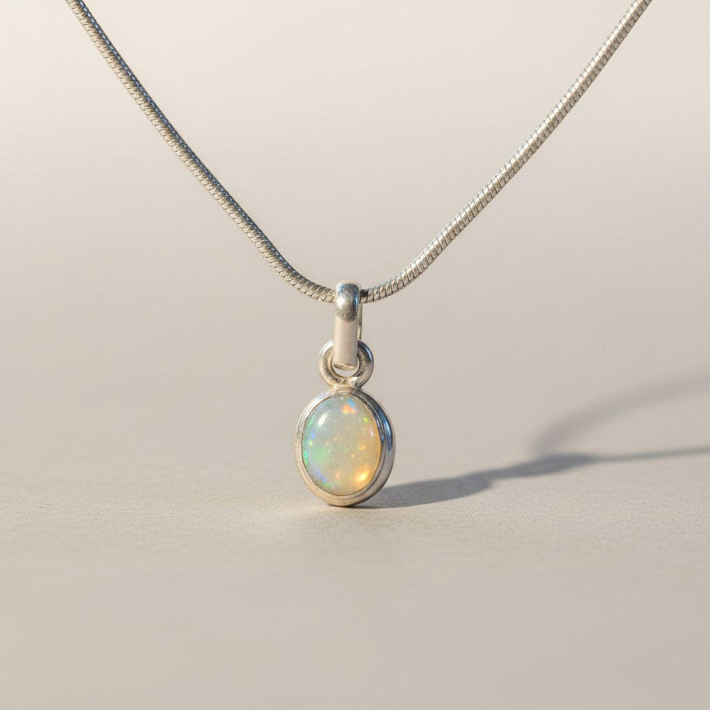 Sinnikäs – Halskette aus 925er Silber mit ovalem Opal-Anhänger, schillernd in Blau, Grün und feurigen Farben.