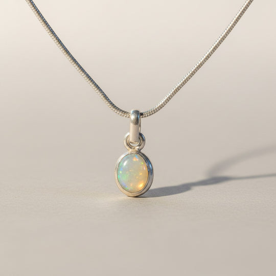 Sinnikäs – Halskette aus 925er Silber mit ovalem Opal-Anhänger, schillernd in Blau, Grün und feurigen Farben.