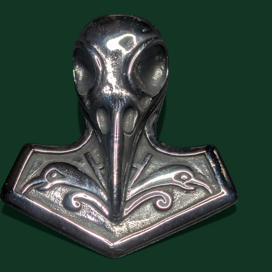 Sinnikäs Raven Skull Thor Hammer-Anhänger aus poliertem Metall mit Rabenköpfen und wirbelnden Mustern. Inspiriert von der nordischen Mythologie.