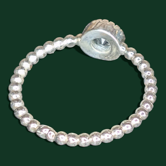 Ein stilvoller Ring aus Sterlingsilber mit geriffeltem Band und einem zentralen, klaren Edelstein als Blickfang.