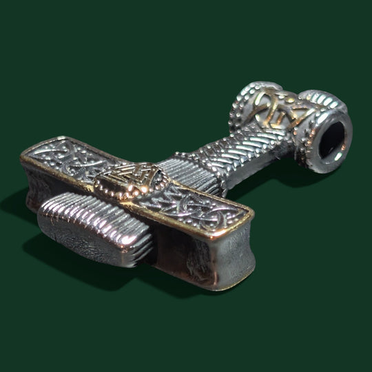 Schicke Halskette mit Thor-Hammer-Anhänger aus silberfarbenem Edelstahl mit goldenen Akzenten, aufwendigen Knotenverzierungen und dem Valknut-Symbol.