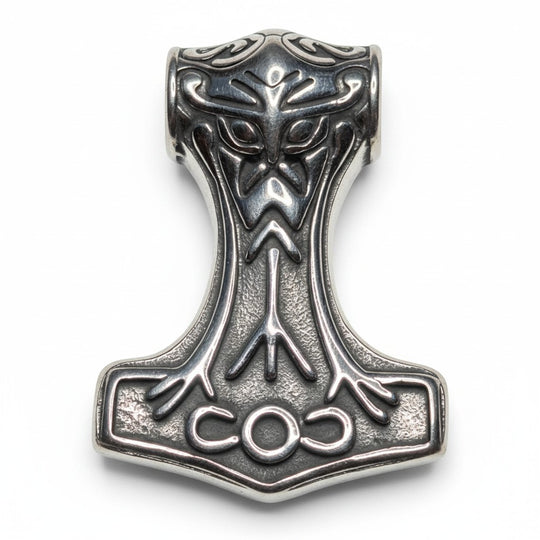 Schicke Thor-Hammer-Halskette aus poliertem Metall mit aufwendigen Wikinger-Motiven, Runensymbolen und einem stilisierten Gesicht.