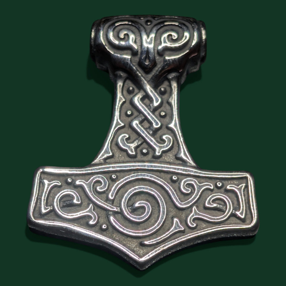 Schicker „Thors Hammer“-Anhänger aus silberfarbenem Edelstahl mit aufwendigen Knotenmustern und wirbelnden Verzierungen. Symbol für Stärke und Schutz.