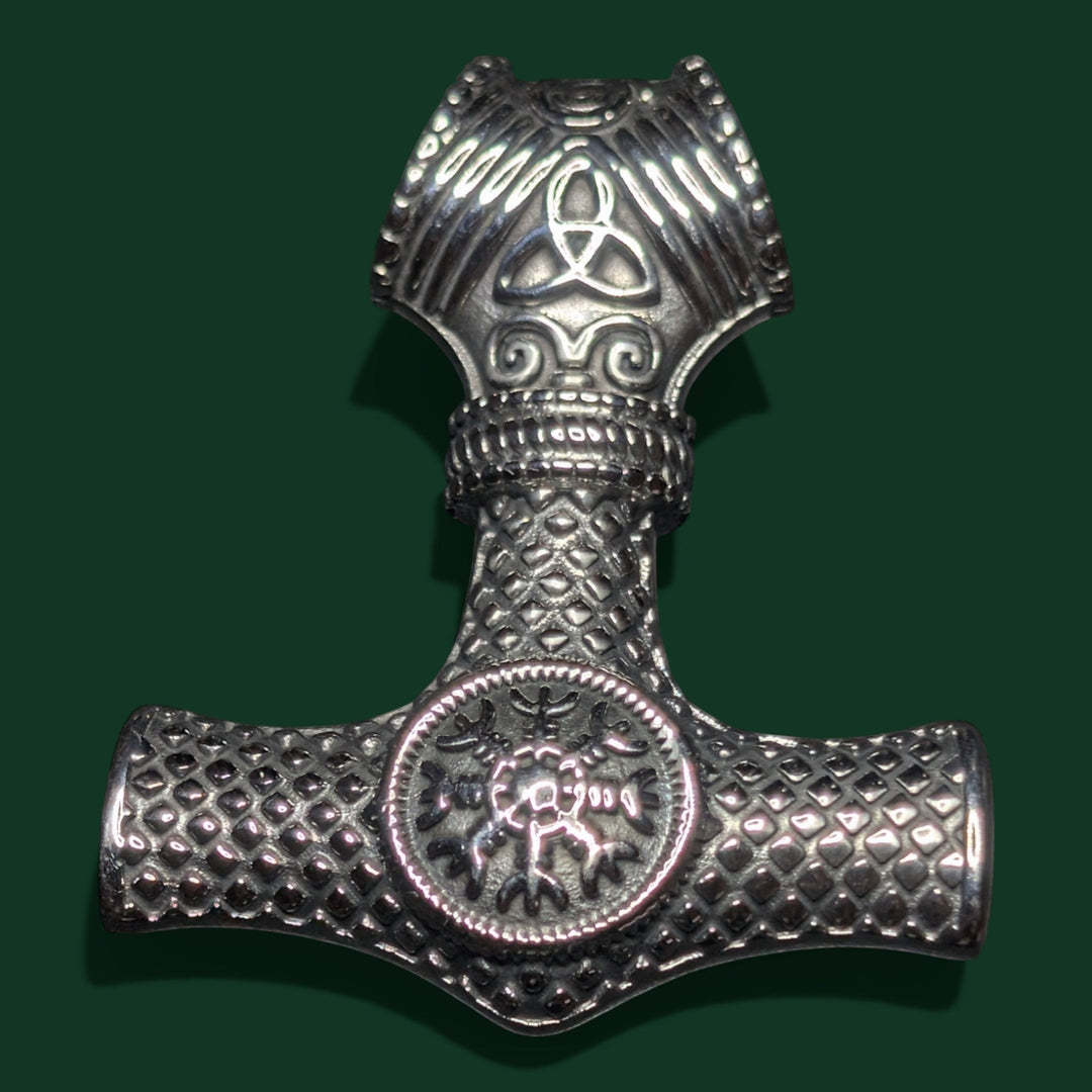 Schicke Viking-Hammer-Halskette aus silberfarbenem Edelstahl mit aufwendigen Knotenverzierungen und einem runden Emblem in der Mitte. Symbol für Stärke und Schutz.