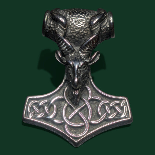 Ein stilvoller Anhänger aus silberfarbenem Edelstahl mit einem detailreichen Ziegenkopf auf einem Thor-Hammer-Motiv mit keltischen Knotenmustern.