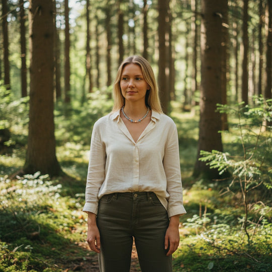 Sinnikäs Aura-Kristall Halskette mit Herzanhänger aus 925 Silber, getragen von einem Model in einem Wald