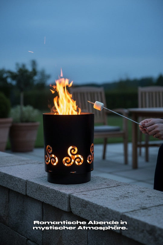 Sinnikäs Feuerstelle aus schwarzem Stahl mit Triskele-Ausschnitten, ideal für den Außenbereich, sorgt für eine mystische Atmosphäre.