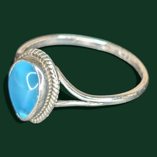 Ein stilvoller Ring aus Sterlingsilber mit einem himmelblauen, tropfenförmigen Edelstein und einem Band in Seiloptik.