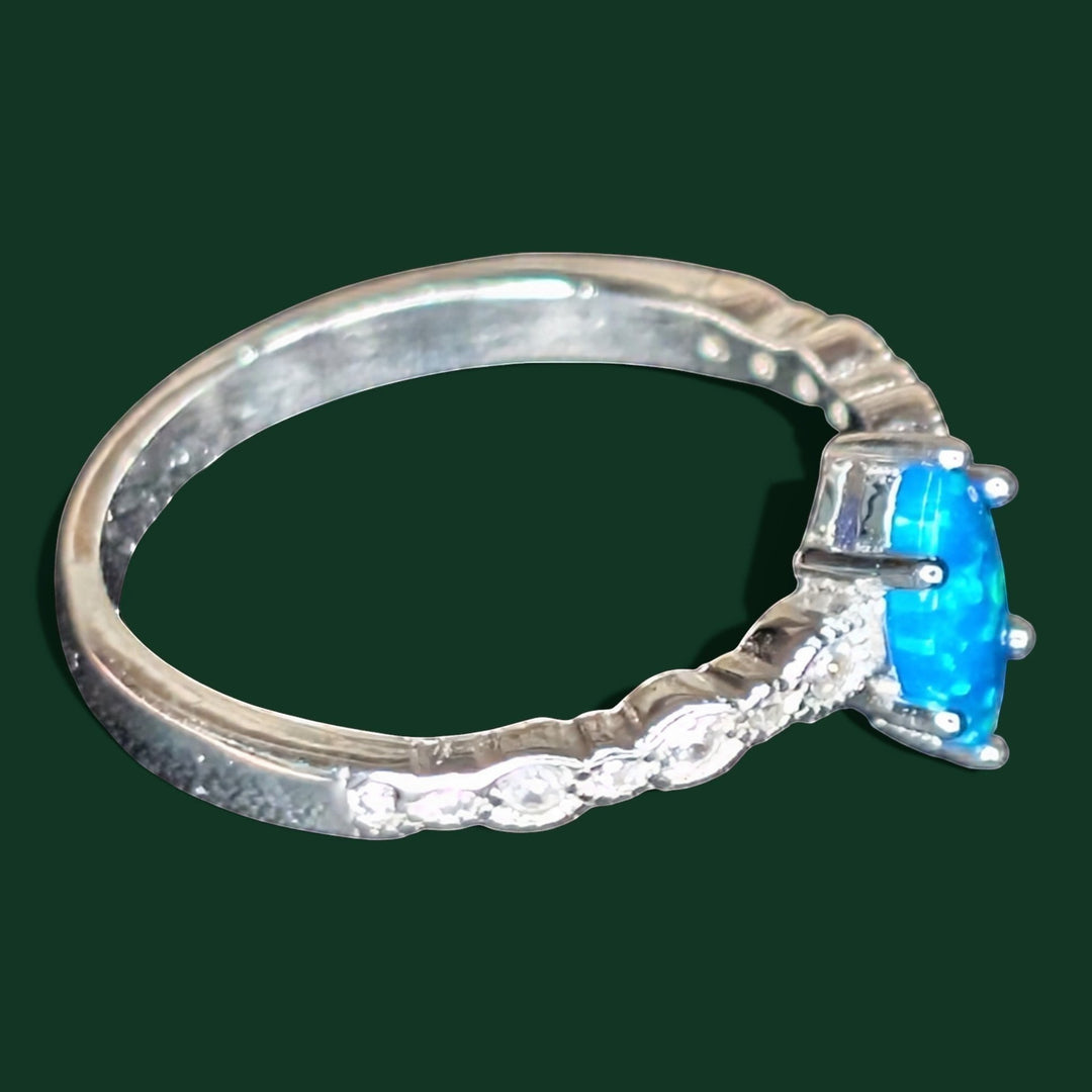 Ein stilvoller Ring aus Sterlingsilber mit einem blauen Opal im Marquise-Schliff als Mittelstein und Zirkonia-Akzenten am Ringband.