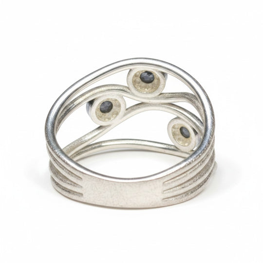 Sinnikäs Ring aus 925er Silber mit drei kleinen, dunklen Labradorit-Steinen in geschwungener Fassung. Größe 58.