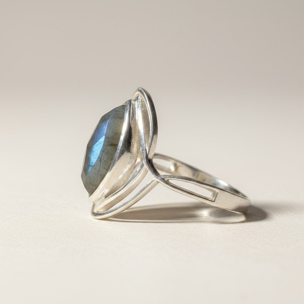 Sinnikäs Sterling-Silber Ring mit facettiertem Labradorit, der blau-grüne Reflexionen zeigt. Eleganter Schmuck mit schlanker Bandführung.