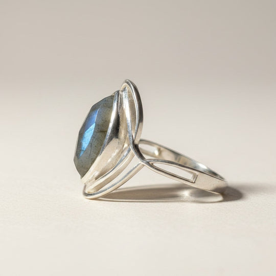 Sinnikäs Sterling-Silber Ring mit facettiertem Labradorit, der blau-grüne Reflexionen zeigt. Eleganter Schmuck mit schlanker Bandführung.