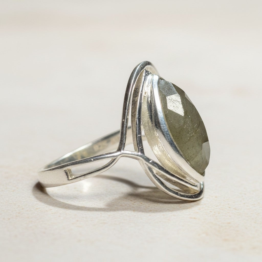 Sinnikäs Sterling-Silber Ring mit facettiertem Labradorit in Tropfenform, der grüne und blaue Reflexe zeigt.