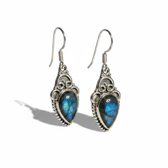 Sinnikäs Sterling-Silber Ohrstecker mit facettiertem Labradorit im Tropfen-Schliff, irisierend blau und grün, mit filigranen Verzierungen.