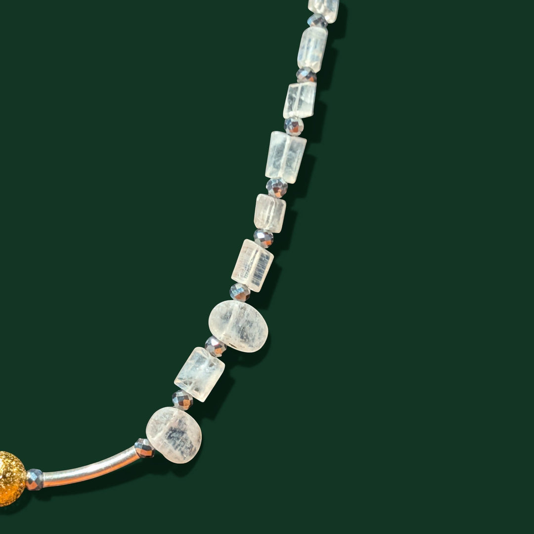 Sinnikäs necklace with faceted moonstone, silicon beads, and a gold-plated sphere on a silver chain.