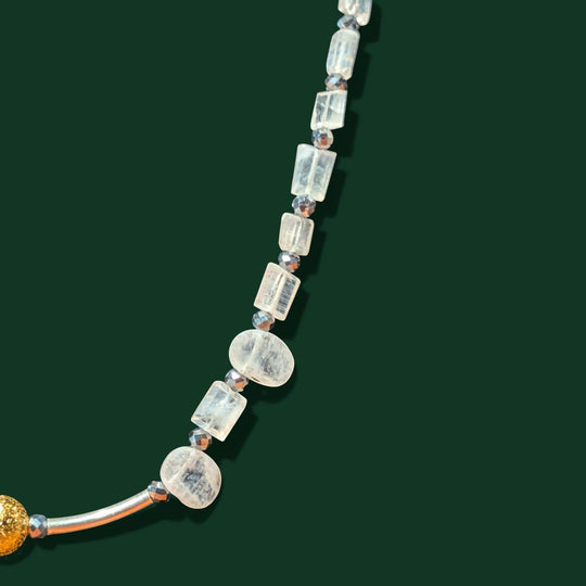 Sinnikäs necklace with faceted moonstone, silicon beads, and a gold-plated sphere on a silver chain.