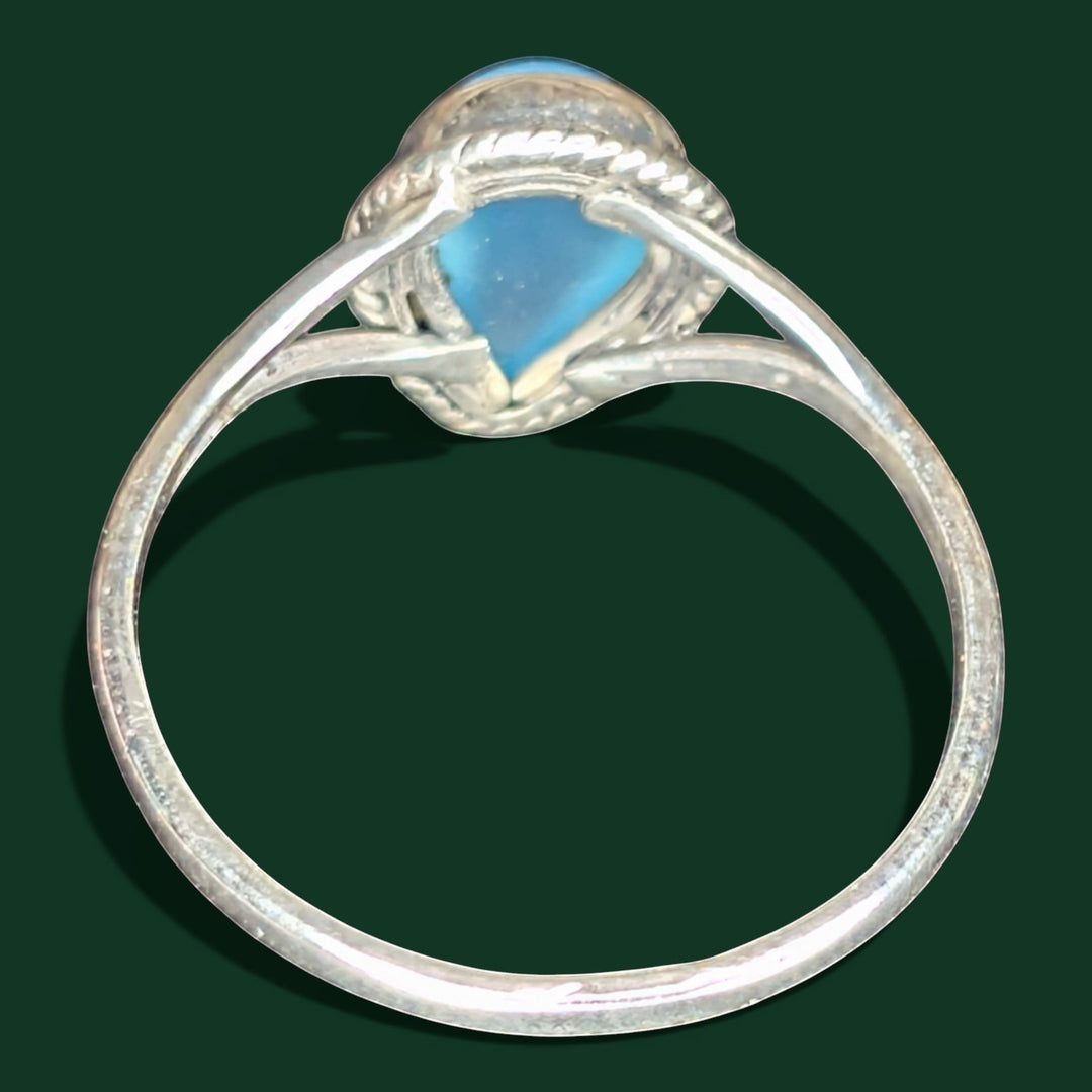 Ein stilvoller Ring aus Sterlingsilber mit einem himmelblauen, tropfenförmigen Edelstein und einem Band mit Seilstruktur.