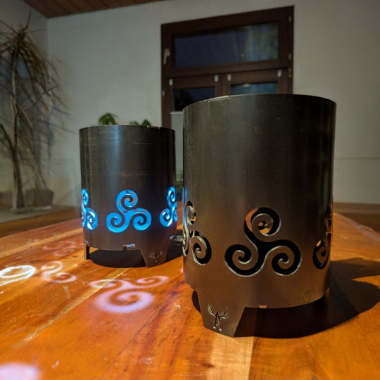 Praktische „Triskele“-Gartenfackel aus Stahl mit keltischem Symbol und blauer LED-Lichtprojektion.