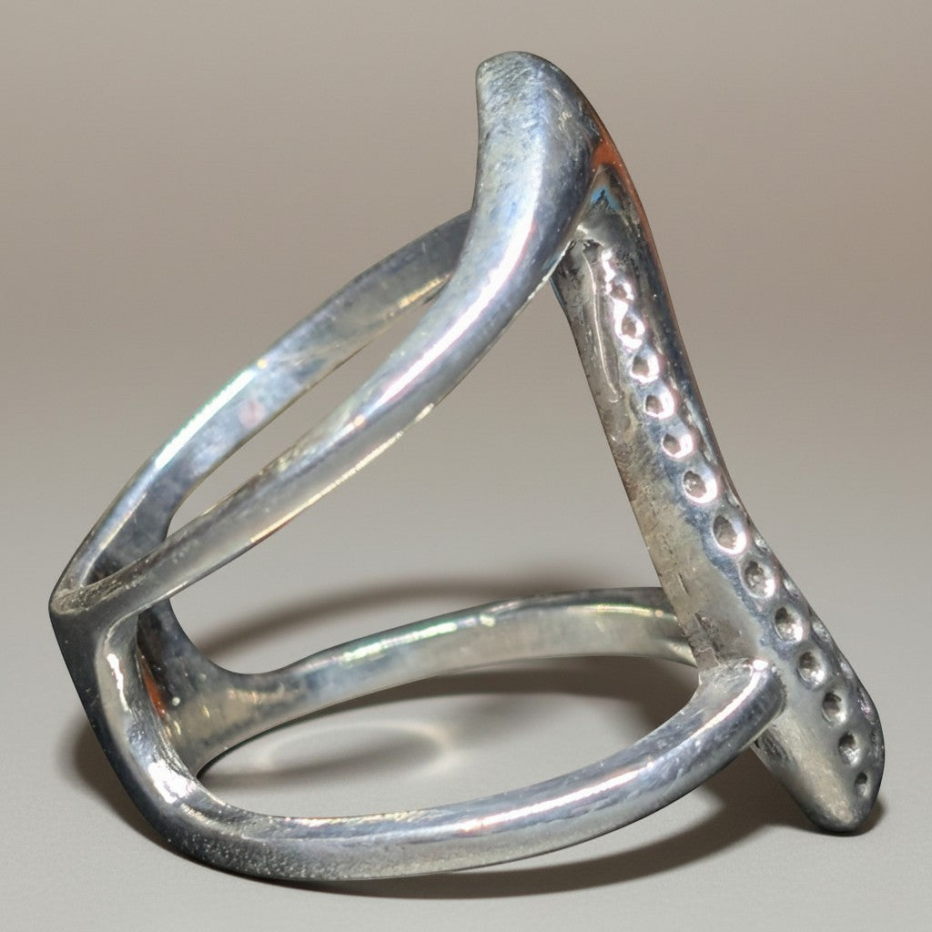 Sinnikäs Twistet Ring aus Sterling-Silber 925 mit rhodinierter Oberfläche und einem modernen, asymmetrischen Design.